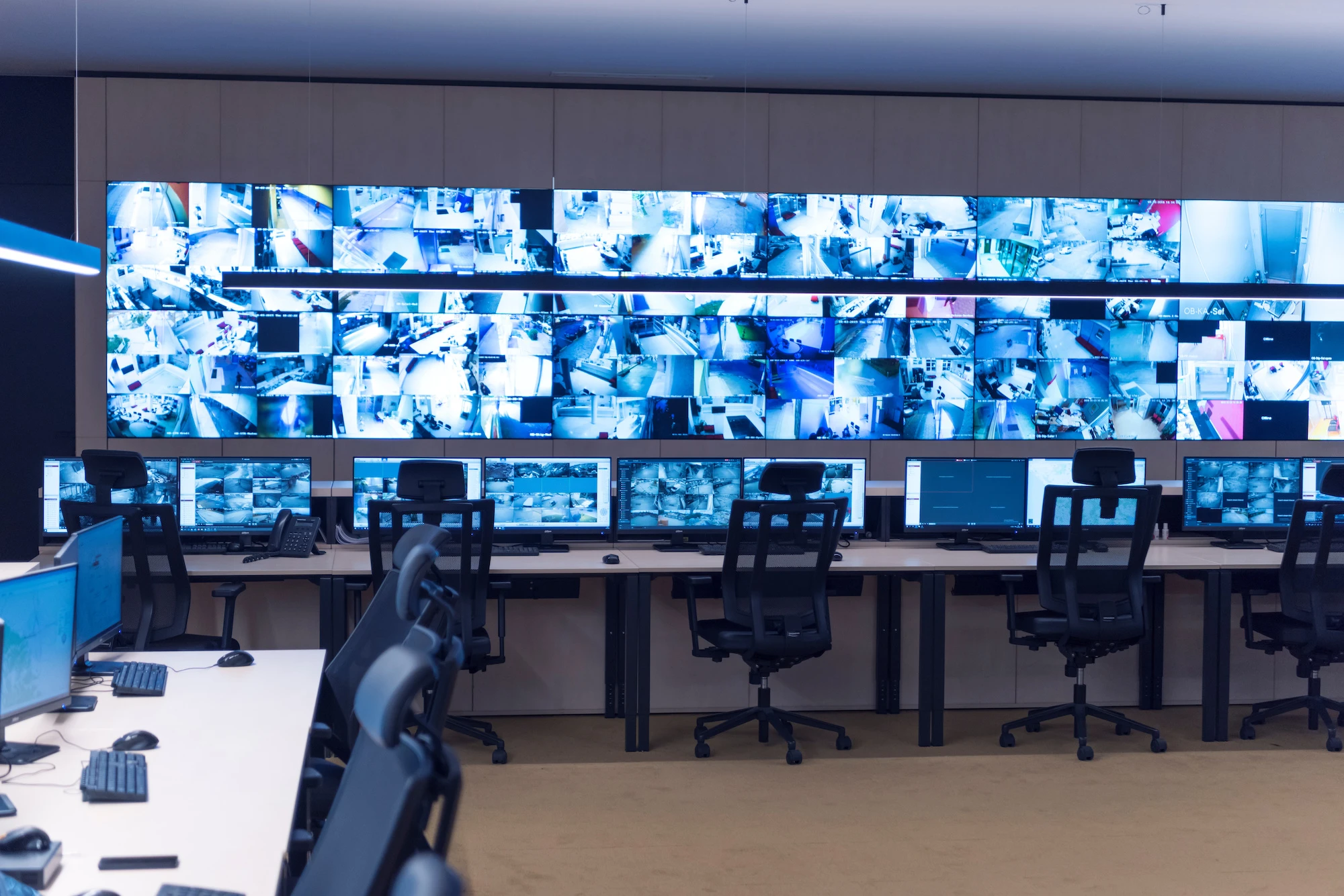 Security guard monitoring modern CCTV cameras in surveillance room